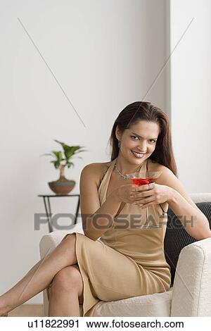 Stock Image - Portrait of smiling woman with cocktail. Fotosearch