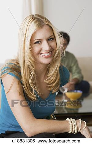 Portrait of smiling woman with man in background View Large Photo Image Stock Photograph - Portrait of smiling woman with man in background. Fotosearch