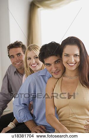 Portrait of two smiling couples sitting on sofa View Large Photo Image Picture - Portrait of two smiling couples sitting on sofa. Fotosearch