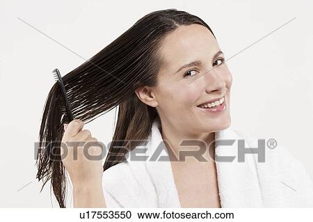 Portrait of woman combing wet hair, studio shot View Large Photo Image Stock Image - Portrait of woman combing wet hair, studio shot. Fotosearch