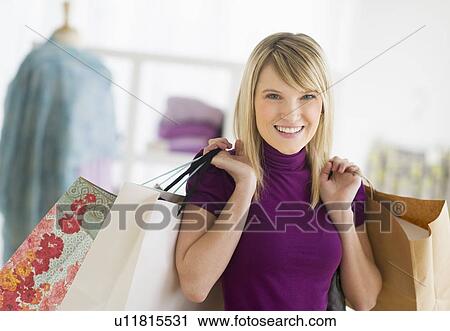 Stock Image - Portrait of woman holding shopping bags. Fotosearch