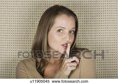 Stock Photography - Portrait of woman making hushing gesture. Fotosearch