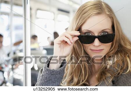Portrait of woman wearing sunglasses in subway train View Large Photo Image Stock Photography - Portrait of woman wearing sunglasses in subway train. Fotosearch