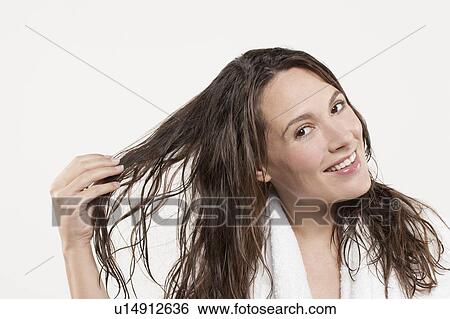 Stock Photograph - Portrait of woman with long wet hair, studio shot. Fotosearch