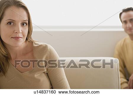 Stock Image - Portrait of woman with man in background. Fotosearch