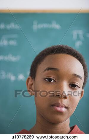 Portrait of young schoolboy in front of blackboard View Large Photo Image Stock Photo - Portrait of young schoolboy in front of blackboard. Fotosearch