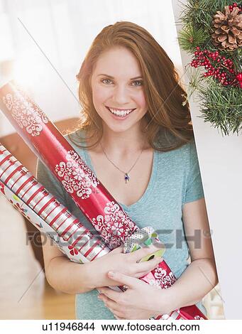Portrait of young woman holding wrapping paper View Large Photo Image Picture - Portrait of young woman holding wrapping paper. Fotosearch