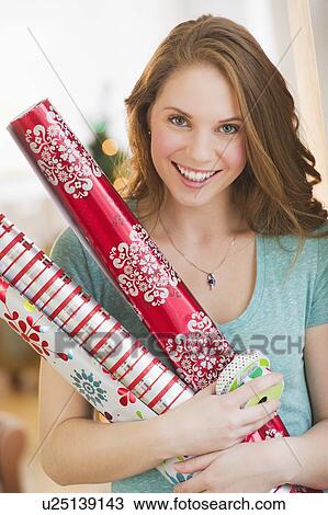 Portrait of young woman holding wrapping paper View Large Photo Image Stock Image - Portrait of young woman holding wrapping paper. Fotosearch