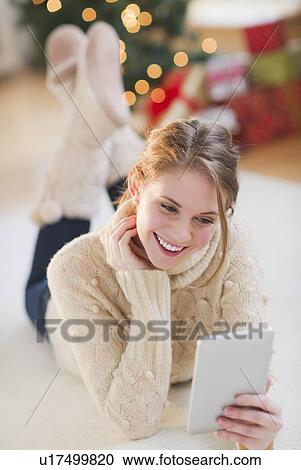 Portrait of young woman lying on floor with digital tablet View Large Photo Image Stock Image - Portrait of young woman lying on floor with digital tablet. Fotosearch