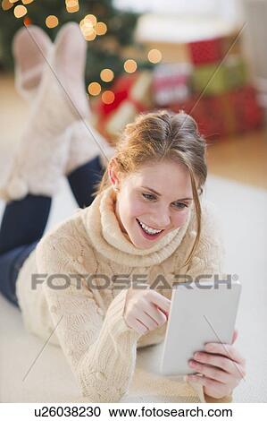 Portrait of young woman lying on floor with digital tablet View Large Photo Image Stock Image - Portrait of young woman lying on floor with digital tablet. Fotosearch