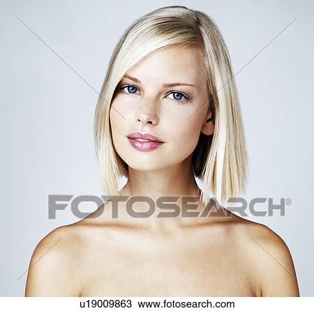 Portrait of young woman on light blue background View Large Photo Image Stock Image - Portrait of young woman on light blue background. Fotosearch