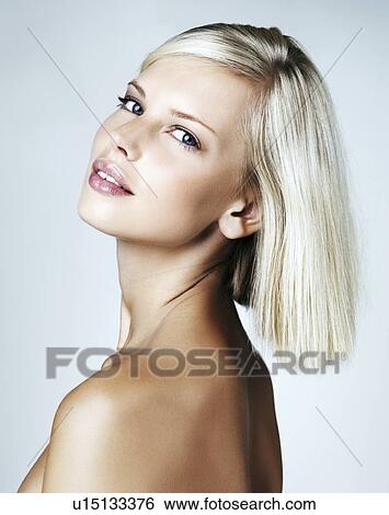 Stock Photograph - Portrait of young woman on light blue background. Fotosearch