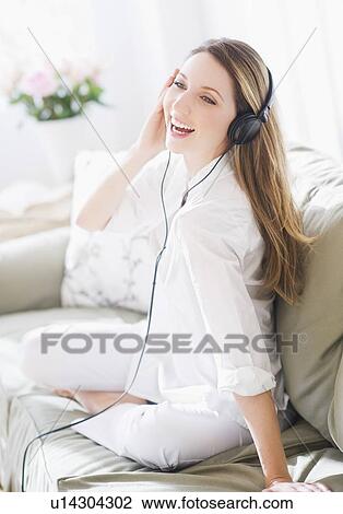 Stock Image - Portrait of young woman wearing headphones. Fotosearch