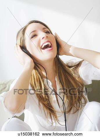Stock Image - Portrait of young woman wearing headphones. Fotosearch