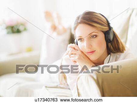Stock Image - Portrait of young woman wearing headphones. Fotosearch