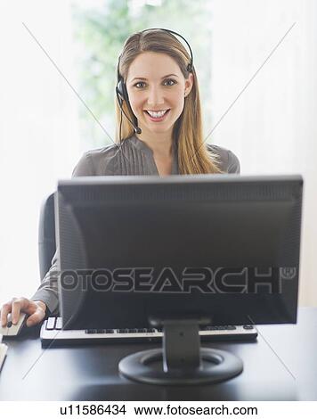 Portrait of young woman with headphones on computer View Large Photo Image Picture - Portrait of young woman with headphones on computer. Fotosearch