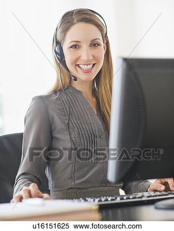 Portrait of young woman with headphones on computer View Large Photo Image Stock Photography - Portrait of young woman with headphones on computer. Fotosearch