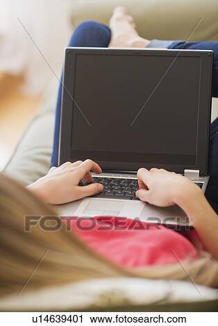 Portrait of young woman with laptop in living room View Large Photo Image Stock Image - Portrait of young woman with laptop in living room. Fotosearch