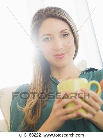 Stock Image - Portrait of young woman with mug. Fotosearch