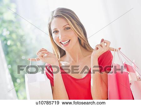 Portrait of young woman with shopping bags View Large Photo Image Stock Photo - Portrait of young woman with shopping bags. Fotosearch