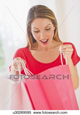 Stock Photography - Portrait of young woman with shopping bags. Fotosearch