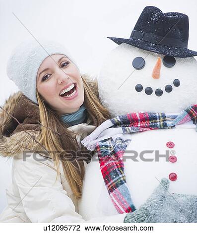 Stock Image - Portrait of young woman with snowman. Fotosearch