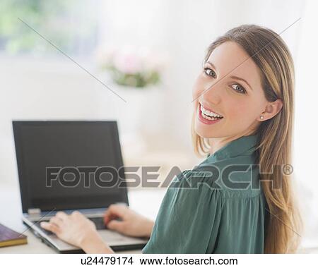 Picture - Portrait of young woman working with laptop. Fotosearch