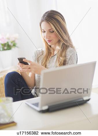 Portrait of young woman working with laptop and mobile phone View Large Photo Image Stock Image - Portrait of young woman working with laptop and mobile phone. Fotosearch