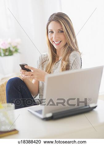 Portrait of young woman working with laptop and mobile phone View Large Photo Image Stock Image - Portrait of young woman working with laptop and mobile phone. Fotosearch
