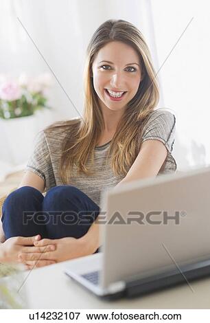 Portrait of young woman working with laptop View Large Photo Image Stock Photo - Portrait of young woman working with laptop. Fotosearch