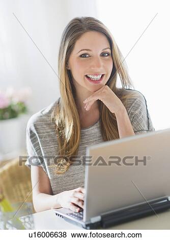 Portrait of young woman working with laptop View Large Photo Image Stock Photo - Portrait of young woman working with laptop. Fotosearch