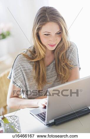 Portrait of young woman working with laptop View Large Photo Image Stock Photo - Portrait of young woman working with laptop. Fotosearch