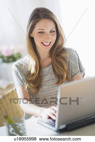 Portrait of young woman working with laptop View Large Photo Image Stock Photo - Portrait of young woman working with laptop. Fotosearch