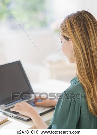 Stock Photograph - Portrait of young woman working with laptop. Fotosearch