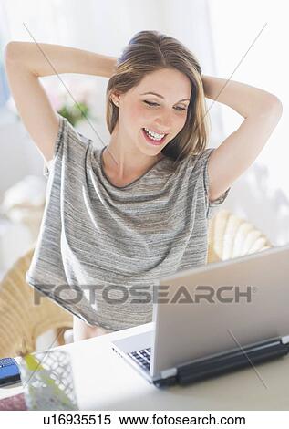 Stock Photography - Portrait of young woman working with laptop. Fotosearch