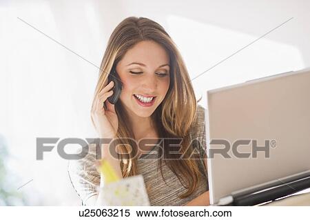 Portrait of young woman working with laptop and mobile phone View Large Photo Image Stock Photography - Portrait of young woman working with laptop and mobile phone. Fotosearch