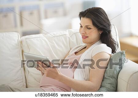 Pregnant woman using tablet pc View Large Photo Image Stock Photography - Pregnant woman using tablet pc. Fotosearch