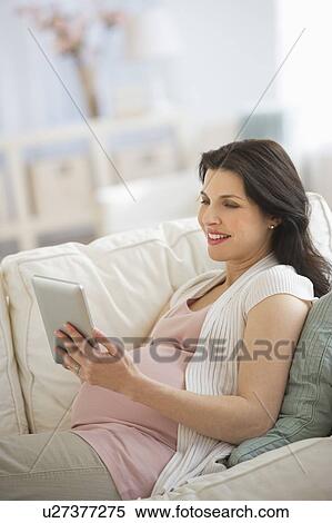 Pregnant woman using tablet pc View Large Photo Image Stock Photography - Pregnant woman using tablet pc. Fotosearch