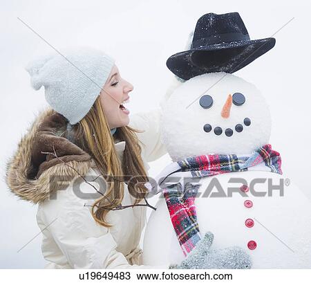 Profile of young woman with snowman View Large Photo Image Stock Image - Profile of young woman with snowman. Fotosearch