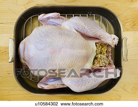 Stock Image - Raw turkey on roasting pan. Fotosearch