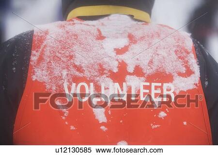 Stock Photography - Rear view of man`s back with volunteer text. Fotosearch