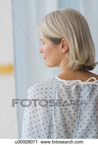 Stock Image - Rear view of senior female patient in hospital. Fotosearch