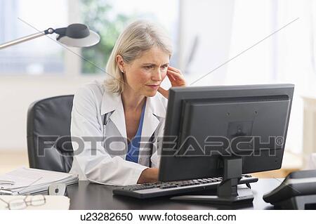 Senior female doctor working in her office View Large Photo Image Stock Image - Senior female doctor working in her office. Fotosearch