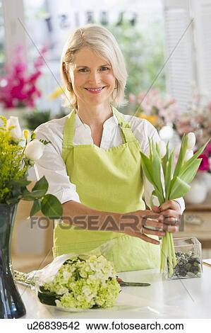 Senior female florist arranging bouquet View Large Photo Image Stock Image - Senior female florist arranging bouquet. Fotosearch