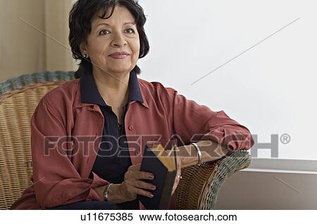 Senior woman holding book and looking away View Large Photo Image Stock Photography - Senior woman holding book and looking away. Fotosearch