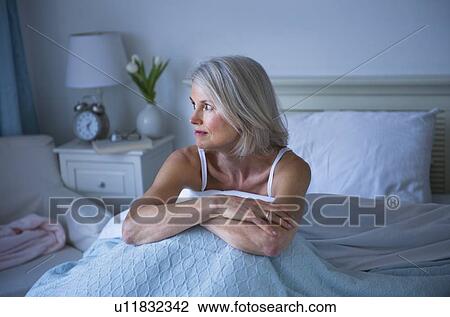 Senior woman sitting in bed and suffering from insomnia View Large Photo Image Stock Image - Senior woman sitting in bed and suffering from insomnia. Fotosearch