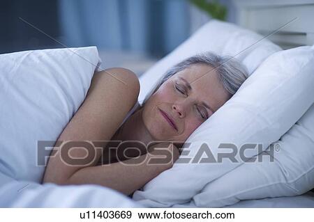 Stock Photo - Senior woman sleeping in bed . Fotosearch
