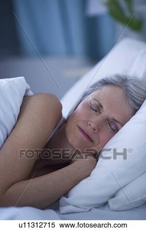 Stock Photography - Senior woman sleeping in bed . Fotosearch