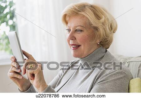 Stock Photograph - Senior woman using digital tablet. Fotosearch