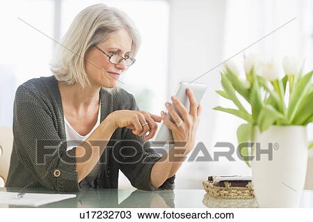 Stock Image - Senior woman working from home. Fotosearch